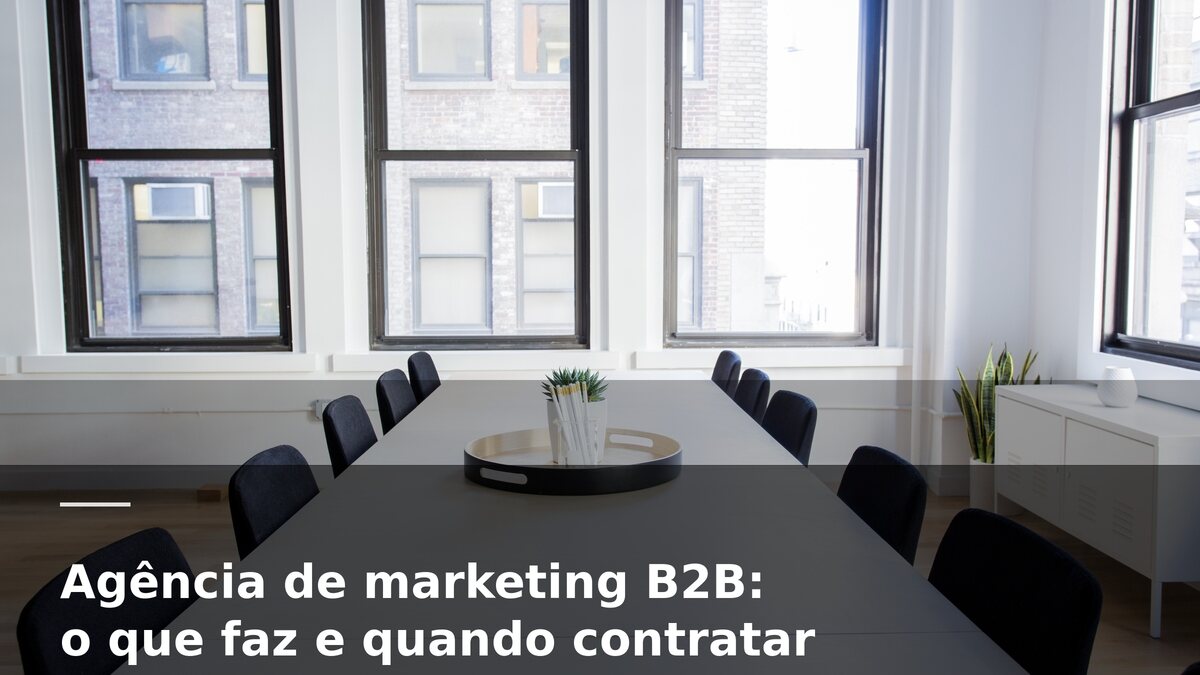 Sala de reunião corporativa com mesa comprida e cadeiras escuras, janelas amplas ao fundo